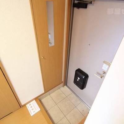 
						鏡付きの下駄箱がある玄関。