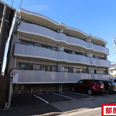 
						タイル張りの3階建てマンション。